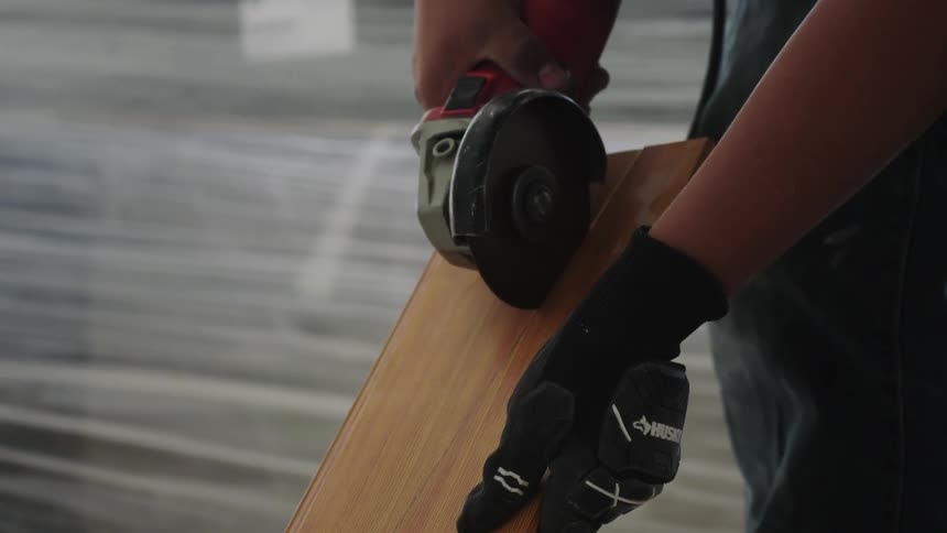 A worker is cutting a piece of plywood
