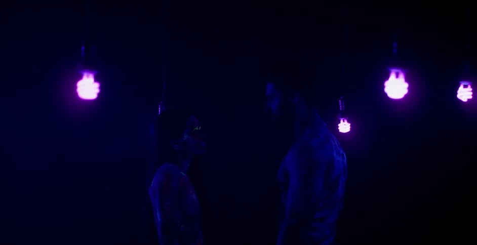 A man and woman embrace in a dark room