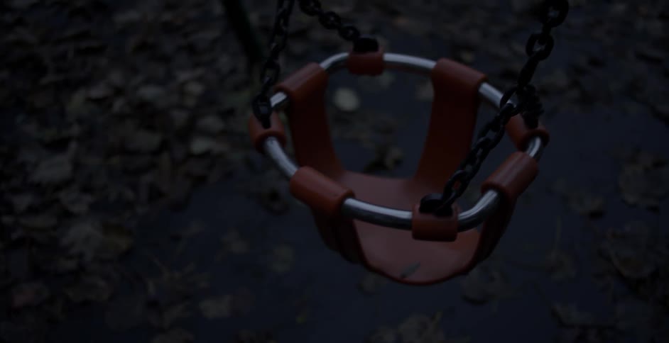 An empty child swing moves back and forth