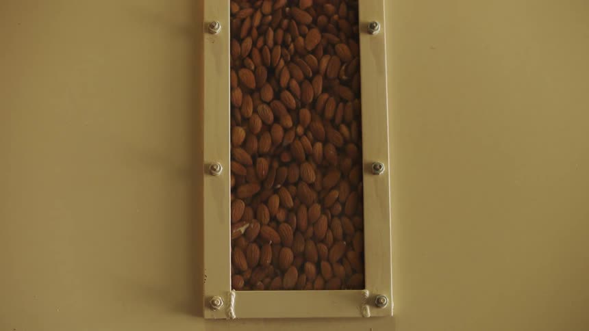 Almonds pour past a window