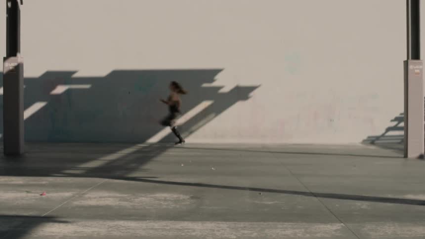 A woman runs across a building front