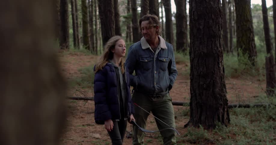 A man and a young woman hike in the woods