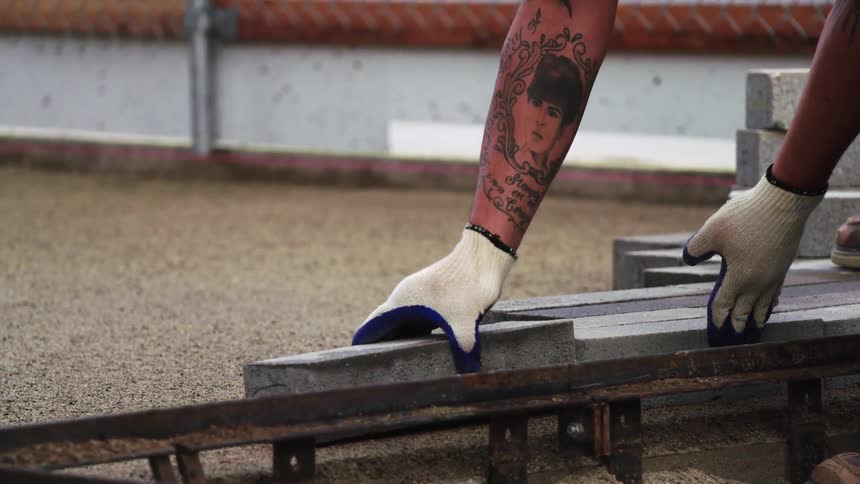 A man is cutting and stacking bricks