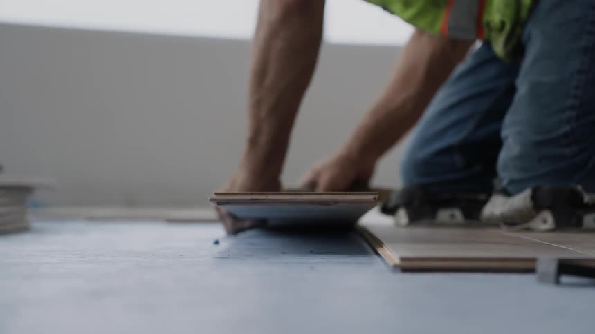 A man is installing a wood floor