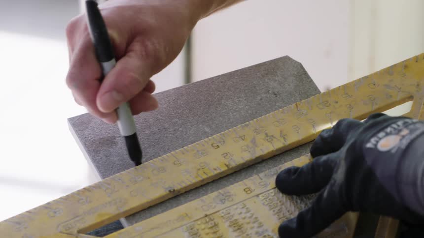 A worker measures and marks with a sharpie