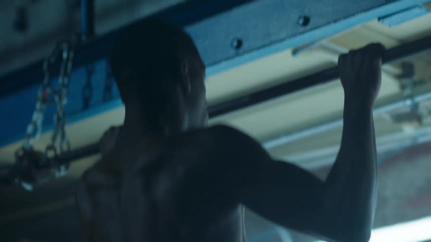 Man does pull ups on a metal bar