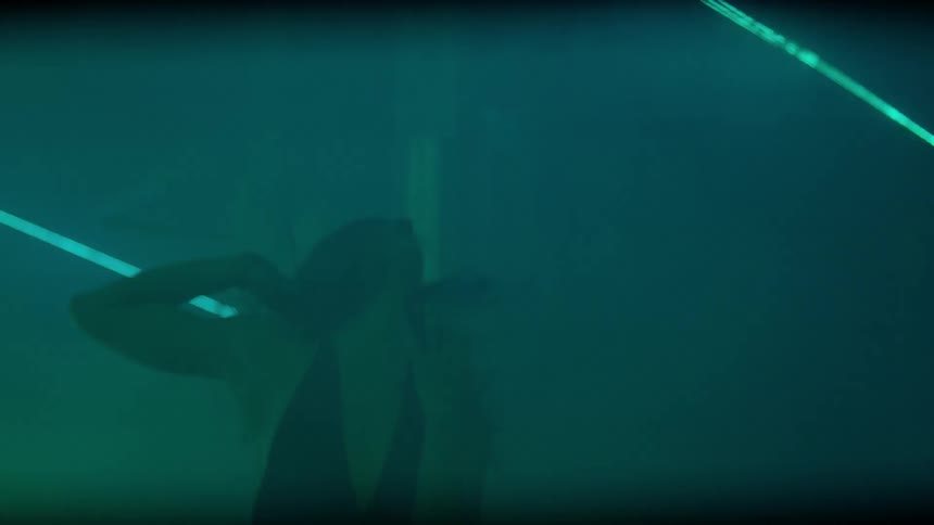 A woman dances in a smoky room