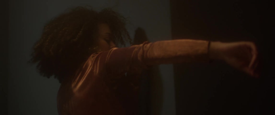 Woman in a shiny jacket performs an interpretive dance