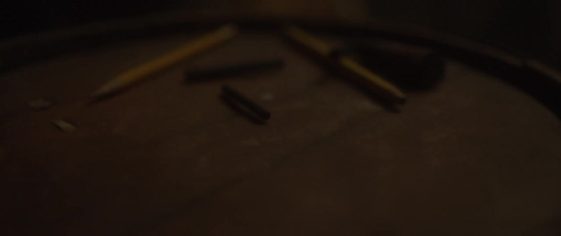 Pencils jostle around on a wood surface