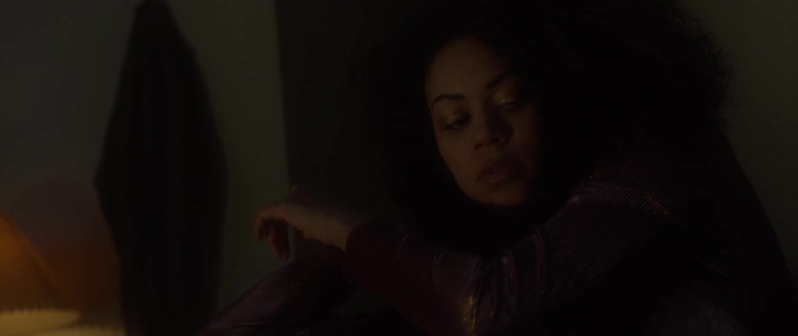 A woman moves her hands around in a dark room