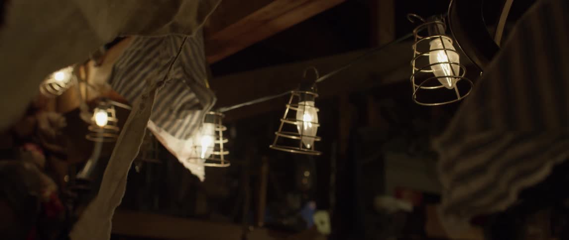 A banner of fabric flags blows in the breeze at night