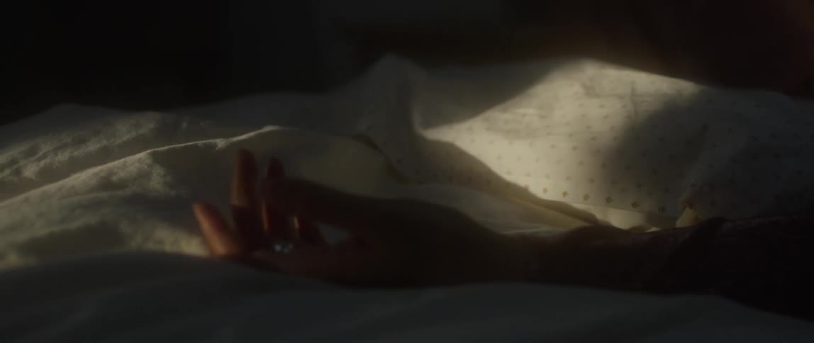 A hand reaches across the blankets