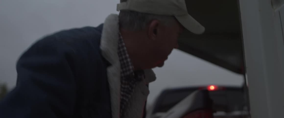 A man turns a crank on a trailer