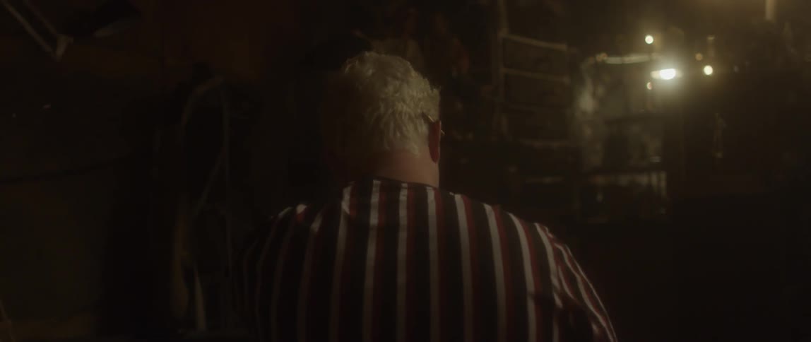 Man wearing a striped shirt in dimly lit room