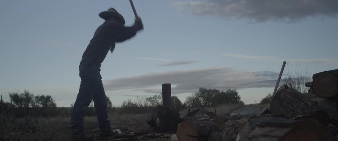 A man chops firewood with an axe