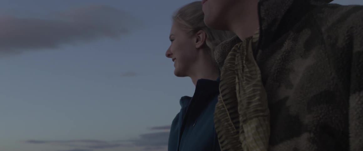 Woman smiles as she talks to a man standing next to her