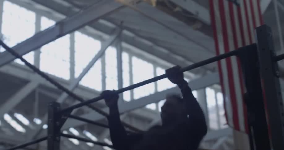 A man does pull ups in a weight room
