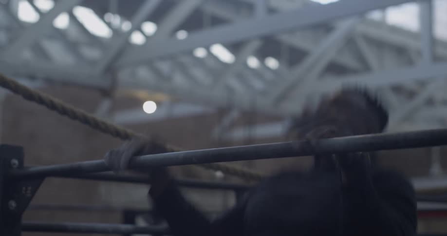 A man does pull up claps in a gym