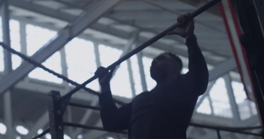 A man does pull ups indoors
