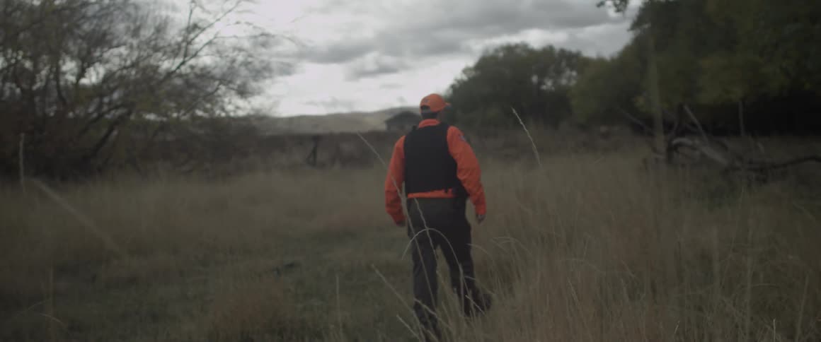 Man in a vest walks in a field