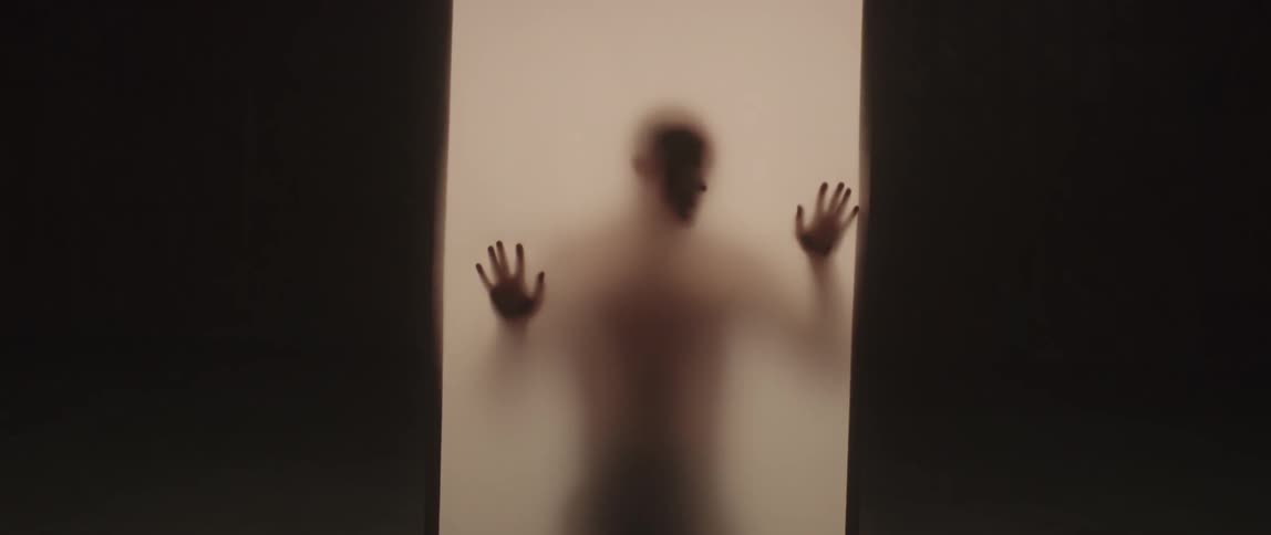Man moves his hands around the inside of an enclosure