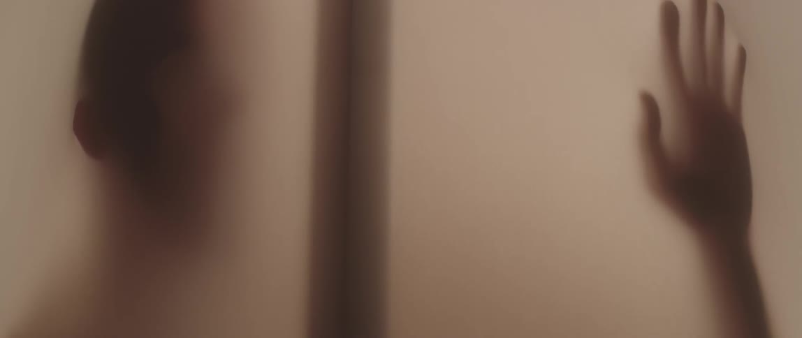A person in this lit room is pressing against the walls
