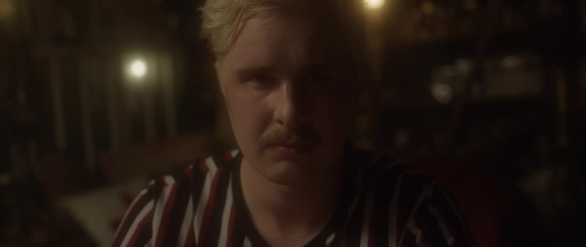 A man is looking forward in a dark area