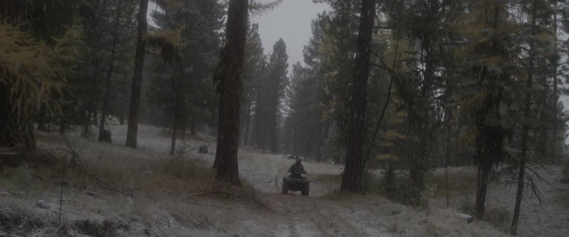 A man rides his four wheeler in the snow