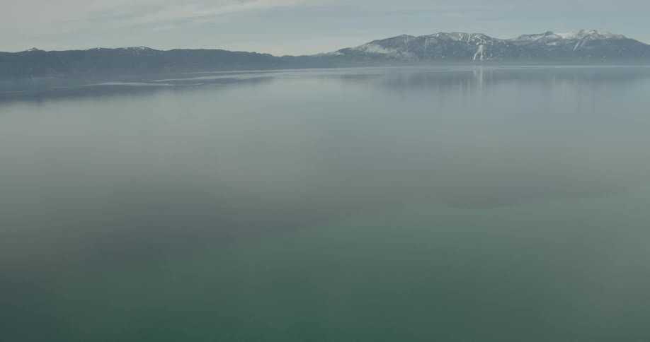A drone is flying over a large calm lake