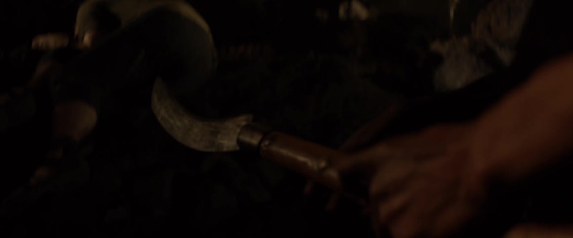 A man is examining a curved knife