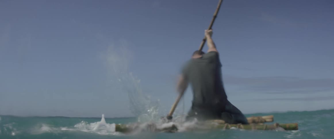 Man uses a paddle while on a raft