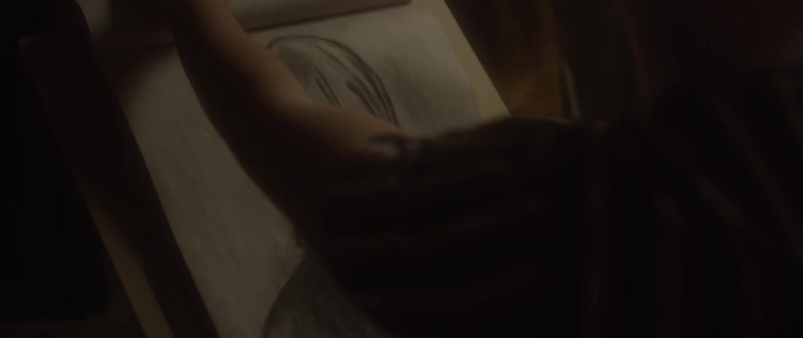 An artist looks at a picture on a canvas