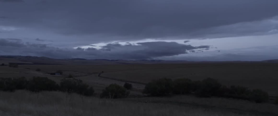 Dark clouds hang over an open field