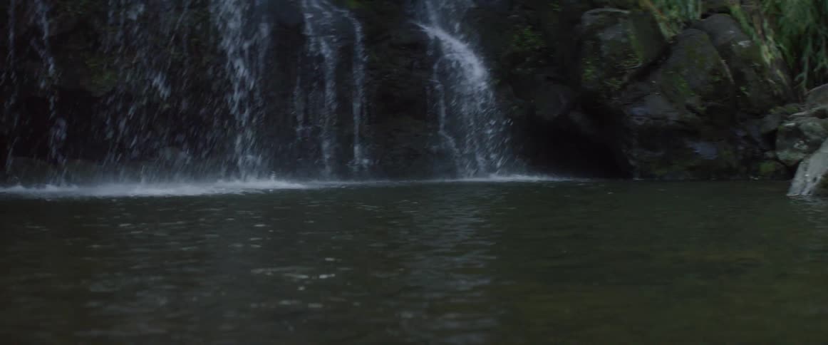 The waterfall is splashing water below on the rocks