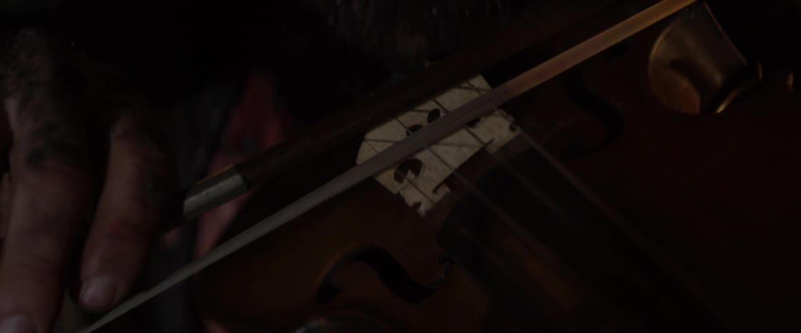 Bow being pushed across violin strings