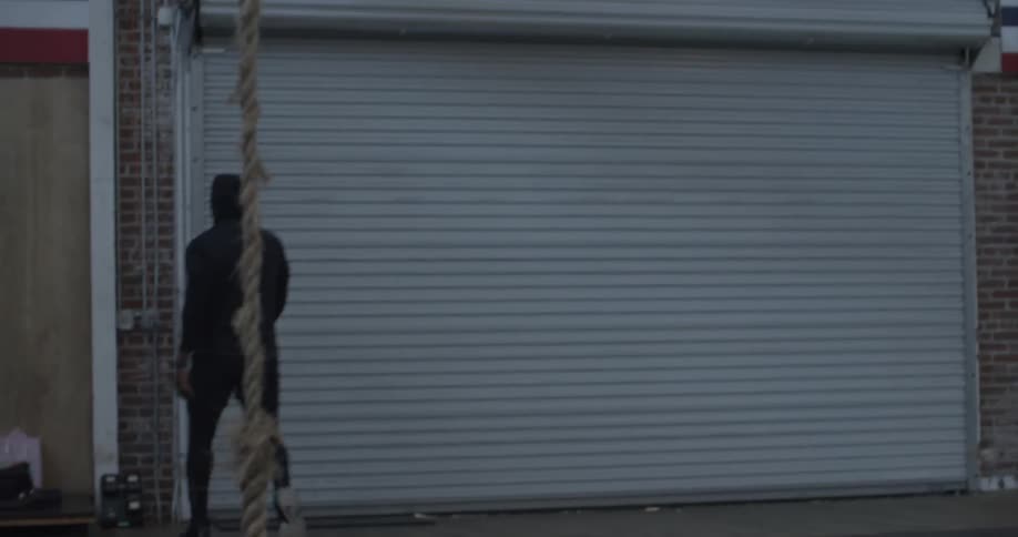 A man walks towards a gate and opens it