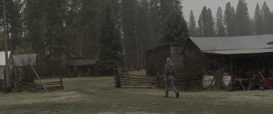 A man walks outside near farm shacks