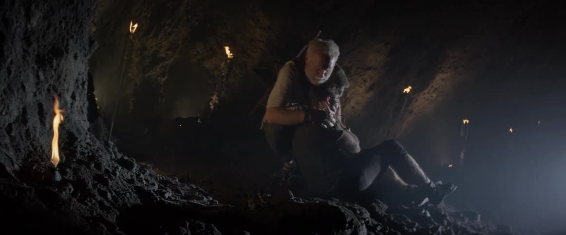 An elderly man tends to a hurt young man