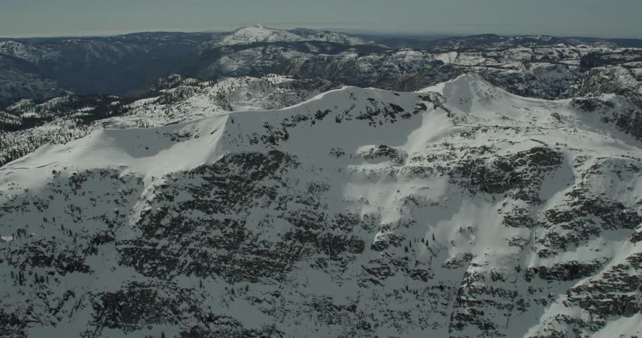 The sun shines on snow covered mountain peaks in Lake Tahoe, California