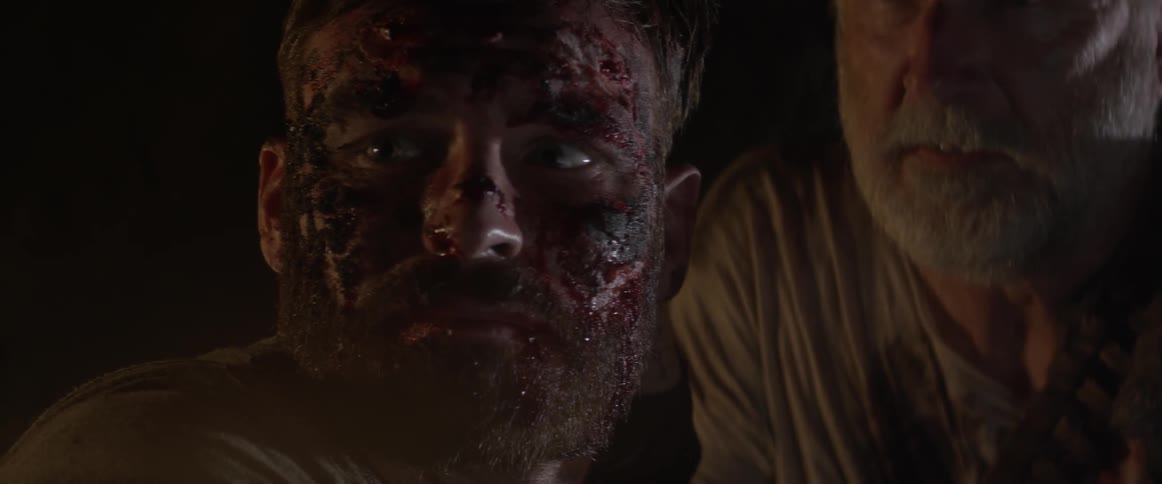 A bloodied man turns away from an older man who holds him