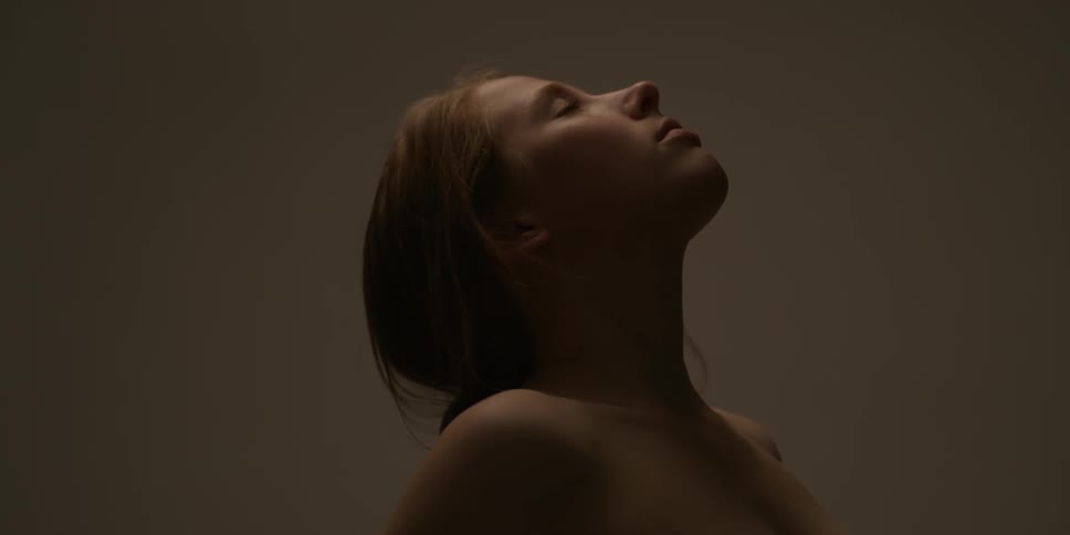 A naked woman arches her back