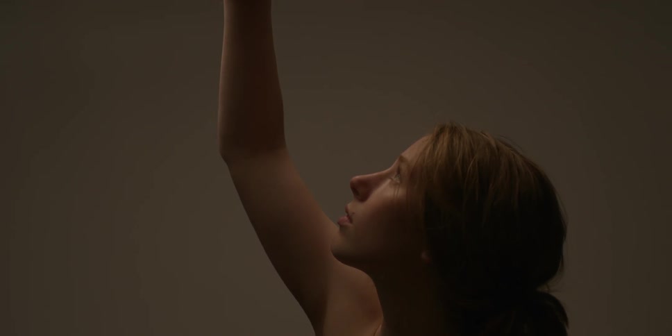 A woman looks up raising her arm