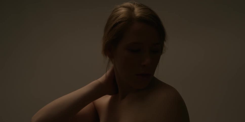 A woman rubs her arm, shoulder and neck with her hand