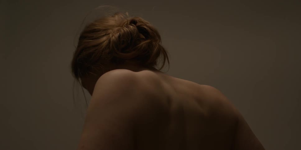 Shirtless woman moves her shoulders