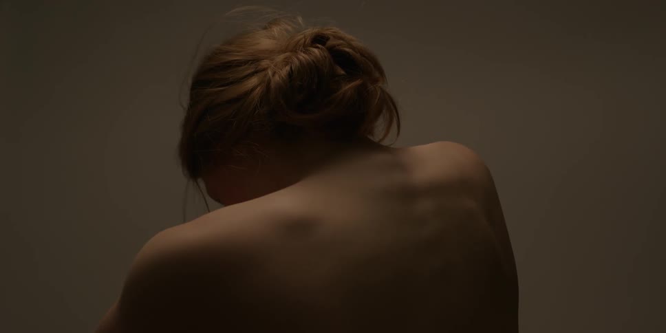 A woman is shrugging her shoulders and looking around