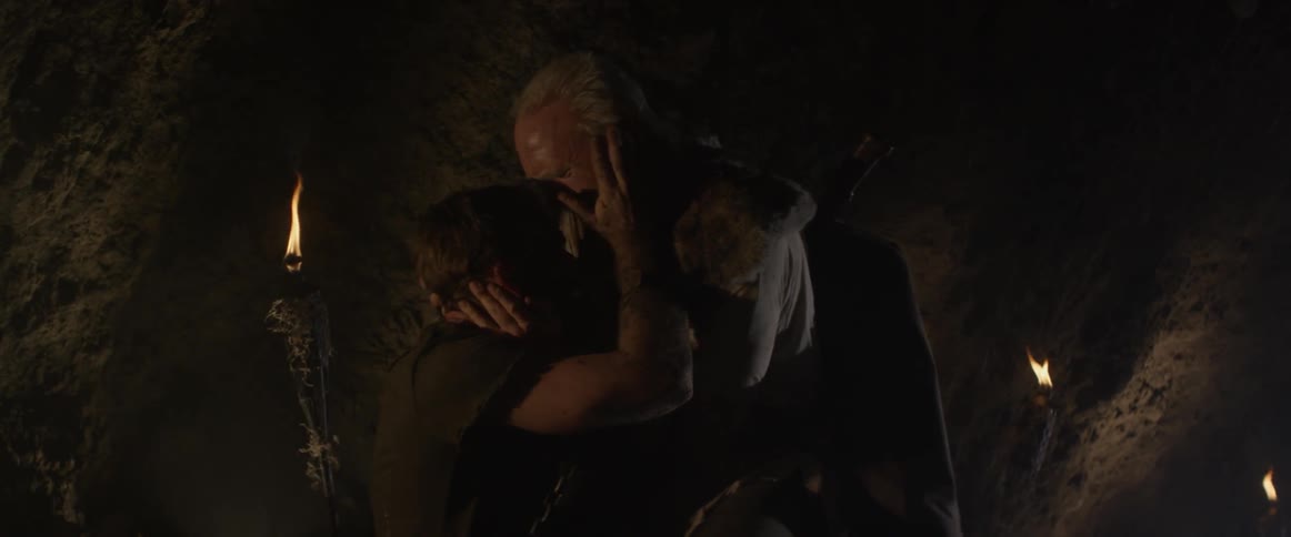 A man picks up an injured man in a cave