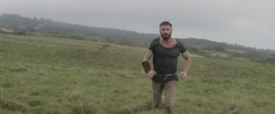 A man is running across a meadow