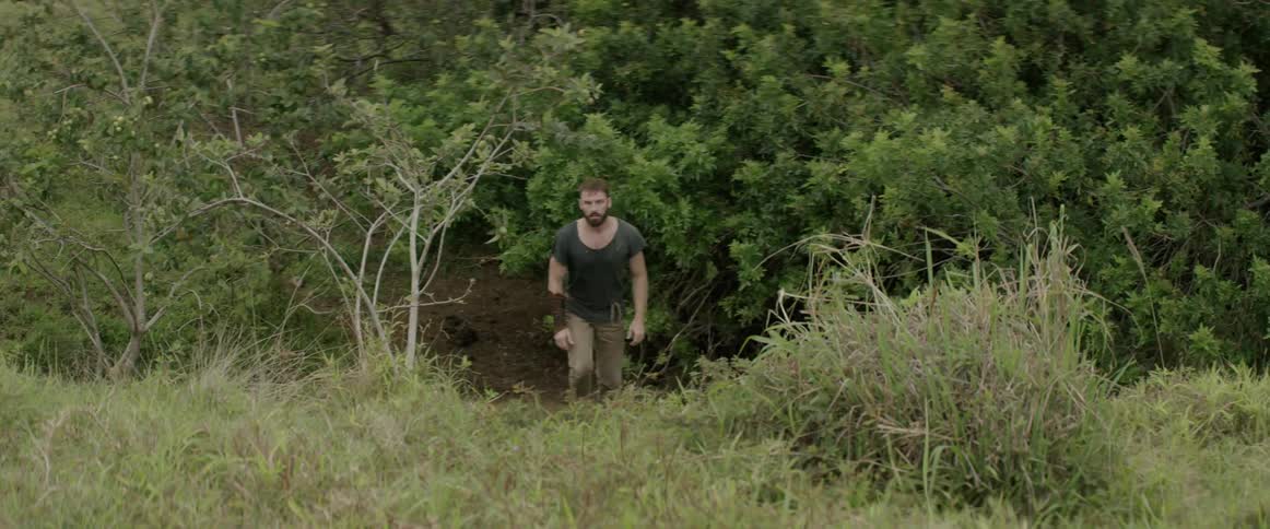 A man runs through the forest down a path