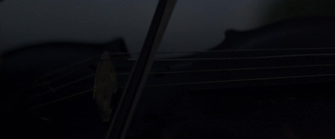 Bow being pushed across violin strings