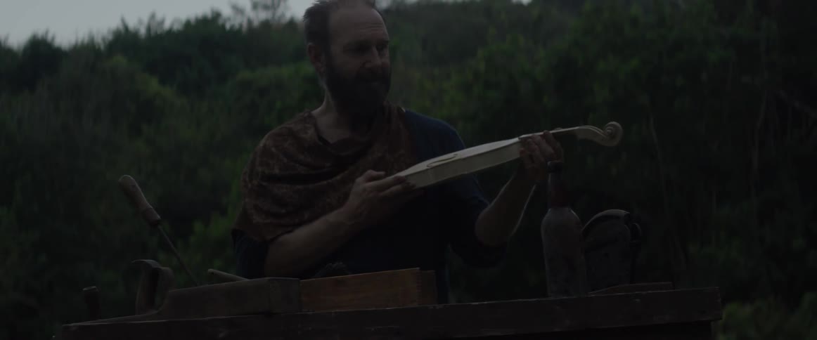 A man crafts a violin outside